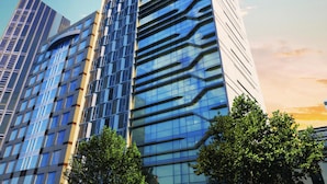 Un edificio moderno de gran altura con ventanales de vidrio reflectante y un diseño angular distintivo.