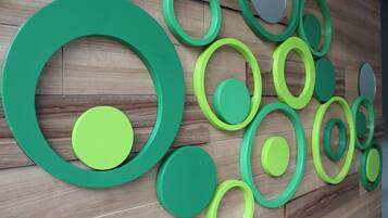 A wall with a pattern of green and grey circular shapes.