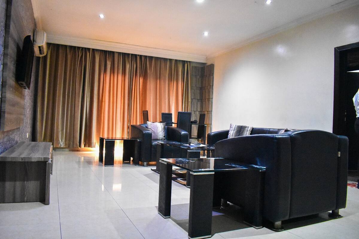 A modern living room with a sofa set, a coffee table, and a flat-screen TV mounted on the wall.