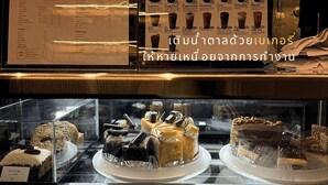 A bakery display case with various pastries and cakes, including a carrot cake and almond croissant. - Barn and Bed Hostel (Bangkok)