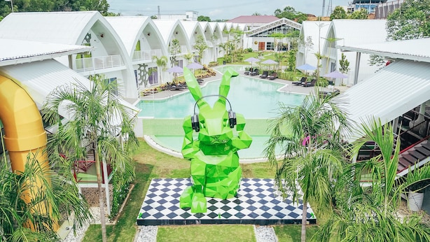 A resort with a central pool, multiple guest rooms, and a distinctive green sculpture. - Dash Box Hotel Cyberjaya (Cyberjaya)