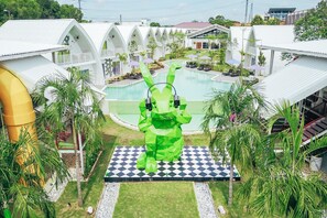 A resort with a central pool, multiple guest rooms, and a distinctive green sculpture. - Dash Box Hotel Cyberjaya (Cyberjaya)