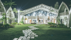 A modern building with a glass facade, a central courtyard with a patterned pathway, and surrounding greenery. - Dash Box Hotel Cyberjaya (Cyberjaya)