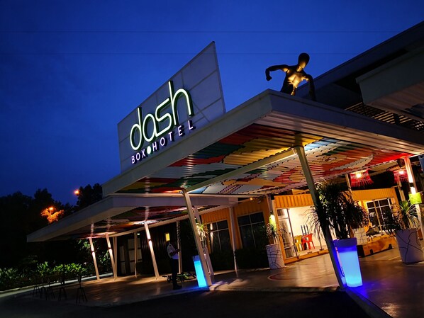 A hotel entrance with a large illuminated sign, a covered outdoor area, and a statue. - Dash Box Hotel Cyberjaya (Cyberjaya)