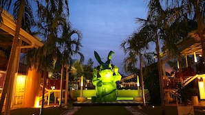 A nighttime view of a resort with a central sculpture, palm trees, and illuminated pathways. - Dash Box Hotel Cyberjaya (Cyberjaya)