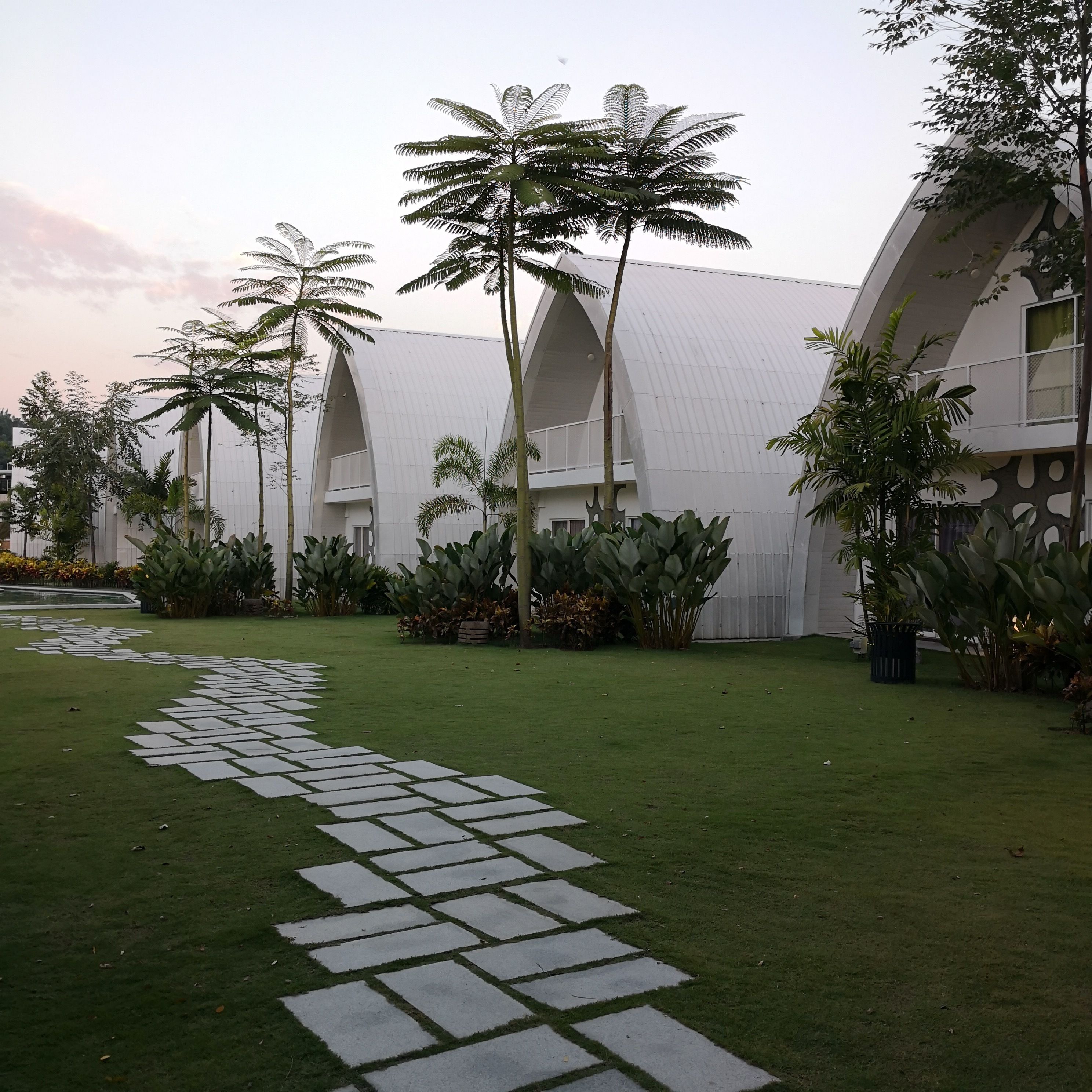 A modern building with a unique architectural design, featuring a curved roof and multiple balconies.