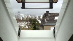 A skylight with a view of residential buildings and trees. - B&B am See - Privatzimmer (Cologne)