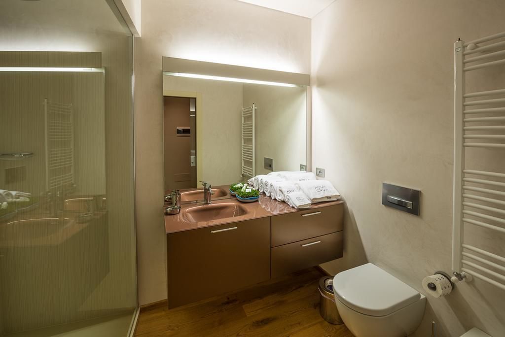 Un bagno moderno con box doccia in vetro, un lavandino con portasciuga e un WC.