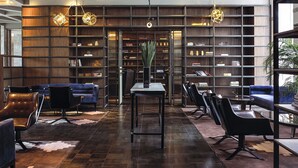 A modern interior with a central table, seating area, and bookshelves. - The Lotus Hotel Chongqing (Chongqing)
