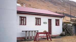 Een wit gebouw met een rood dak en een bord met de tekst receptie.