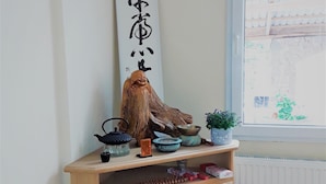 A wooden cabinet with various items including a teapot, bowls, and a decorative piece with calligraphy.
