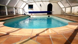 An indoor swimming pool with a tiled floor and glass walls. - Ambition Zen Presles (Presles)