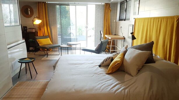 A hotel room with a large bed, a desk, a chair, and a small table. - Ambition Zen Presles (Presles)