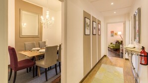 A hotel lobby with a dining area, a fire extinguisher, framed pictures on the wall, and a chandelier. - Spagna Glamour Life Penthouse (Rome)