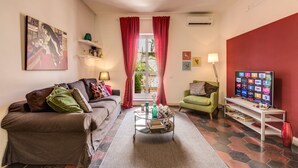 A living room with a sofa, armchair, coffee table, and TV. - Spagna Glamour Life Penthouse (Rome)