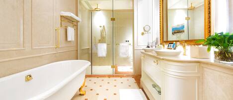 A luxurious bathroom with a freestanding bathtub, a large mirror, and a vanity with a sink.