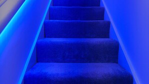 A staircase with blue lighting. - Fewston House Apartments (Leeds)