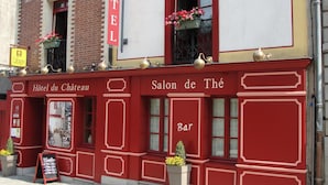 A red and white building with a sign reading "HOTEL" and "Salon de Thé Bar". - Hotel du Chateau (Vitre)