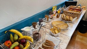 A breakfast buffet with various food items including fruits, bread, pastries, and spreads. - Hotel du Chateau (Vitre)