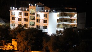 Un edificio de varios pisos con fachada simétrica, ventanas amplias y una torre del reloj central.