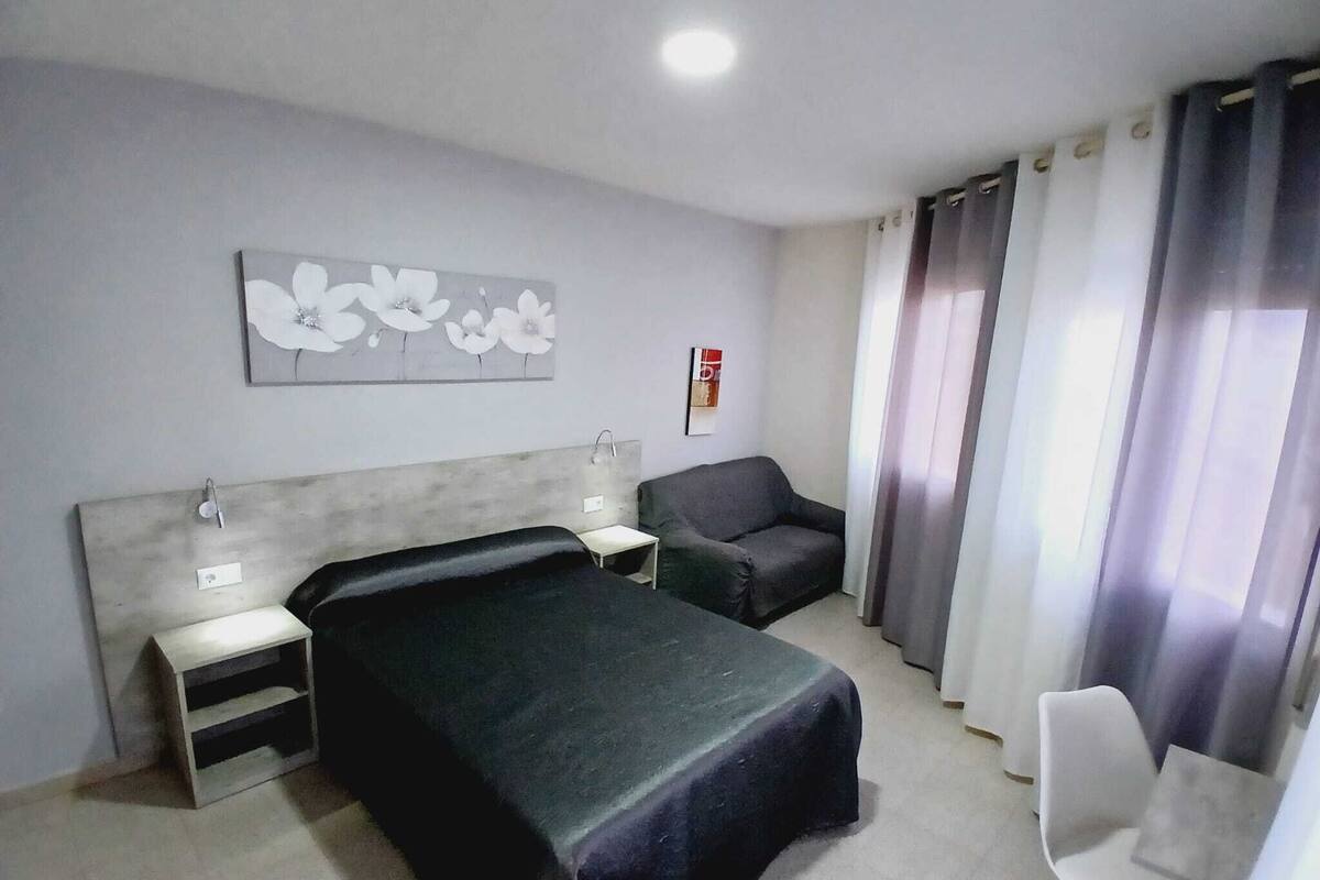 Une chambre d’hôtel comprenant un lit, des tables de chevet, une chaise et un bureau.
