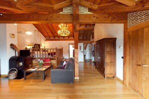 Un salón espacioso con chimenea, muebles de madera y un candelabro.