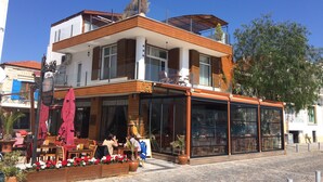 Un edificio de dos pisos con una cafetería en la planta baja.