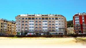 A multi-story hotel with balconies, a cafe bar, and a parking area. - Apartamentos Duerming Sea View Viveiro (Viveiro)
