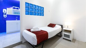 A modern hotel room with a bed, a nightstand, a bathroom with a blue wall, and a white cabinet. - Trevi Elite Rome (Rome)