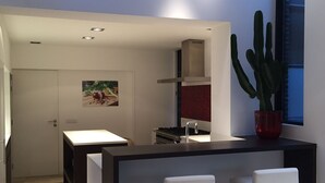 A modern kitchen with a dining area, a large cactus plant, and a door with a picture of food. - B-Square Brugge (Bruges)
