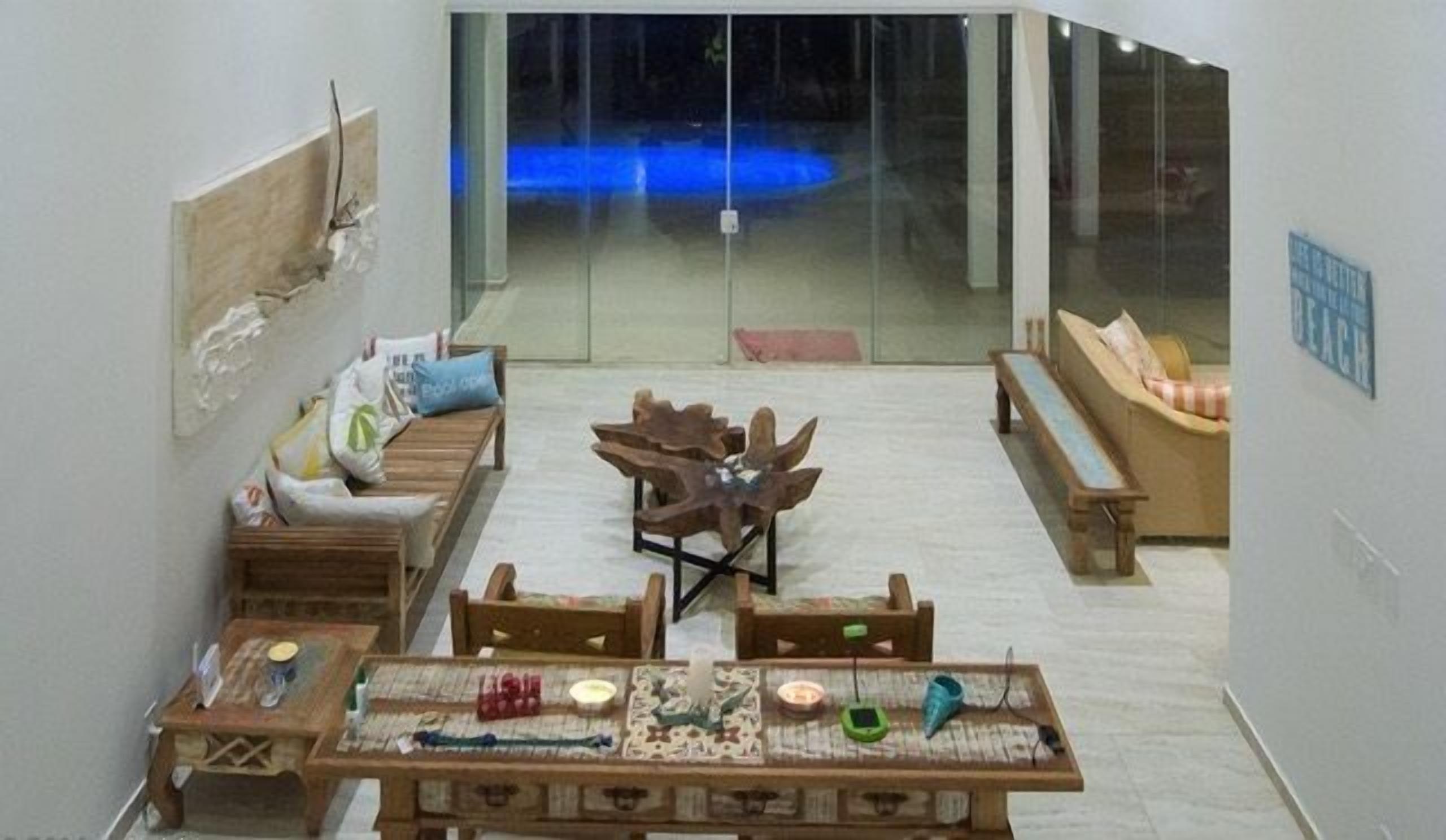 A modern living room with a wooden coffee table, sofas, and a unique wooden sculpture centerpiece.