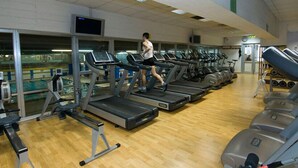 A gym with multiple treadmills, weight machines, and a wooden floor. - Roman Enchantment (Rome)