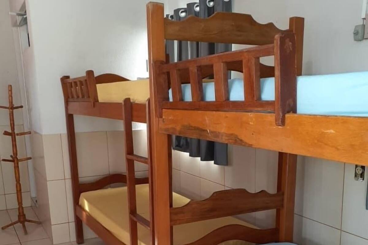 A bunk bed with a blue mattress and a wooden headboard.