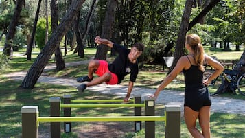Ein Park mit Trainingsgeräten, Bäumen und einem Weg.