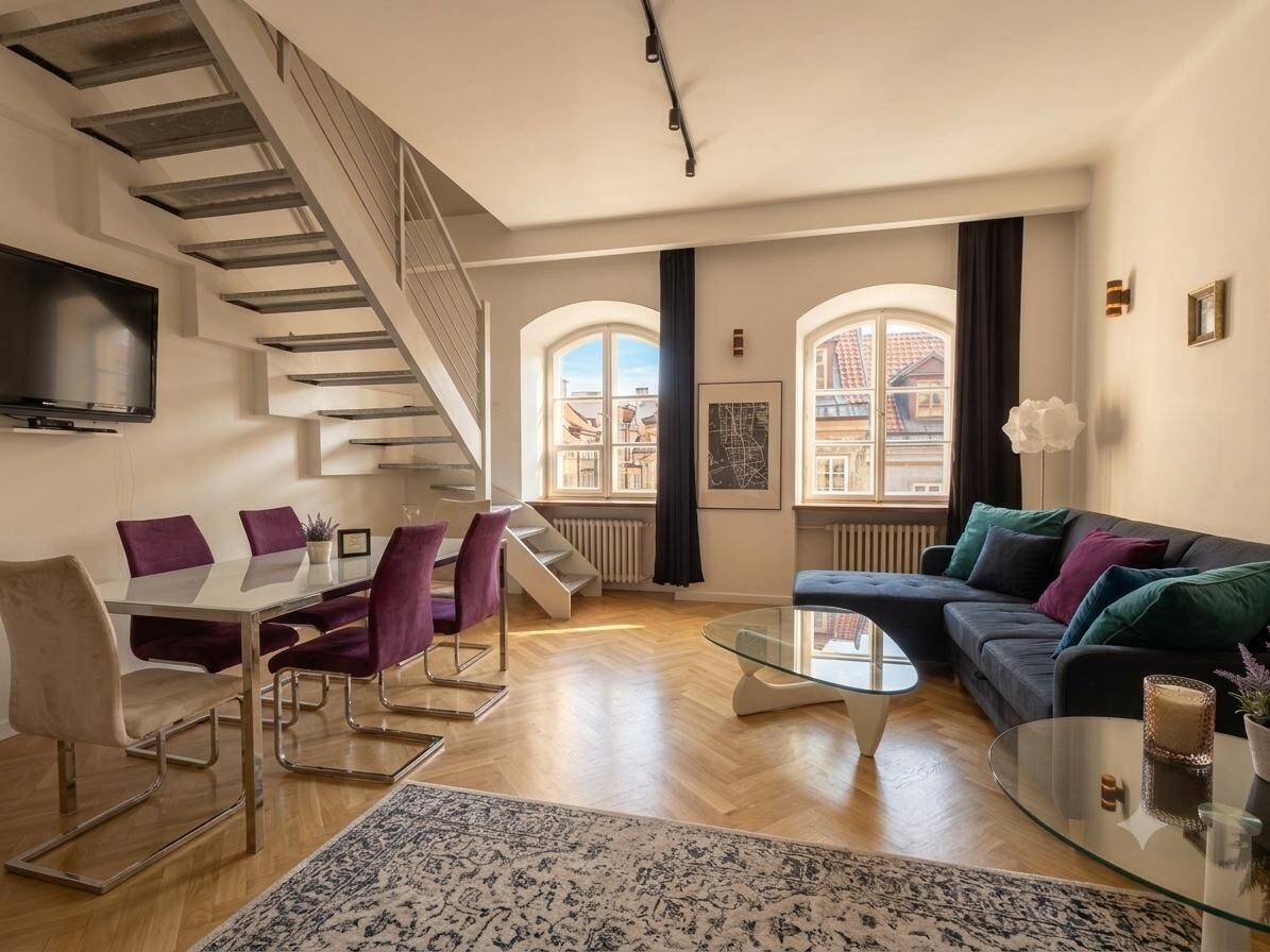 Un salon moderne avec un escalier, un coin repas et un canapé.