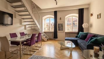 Un salon moderne avec un escalier, un coin repas et un canapé.