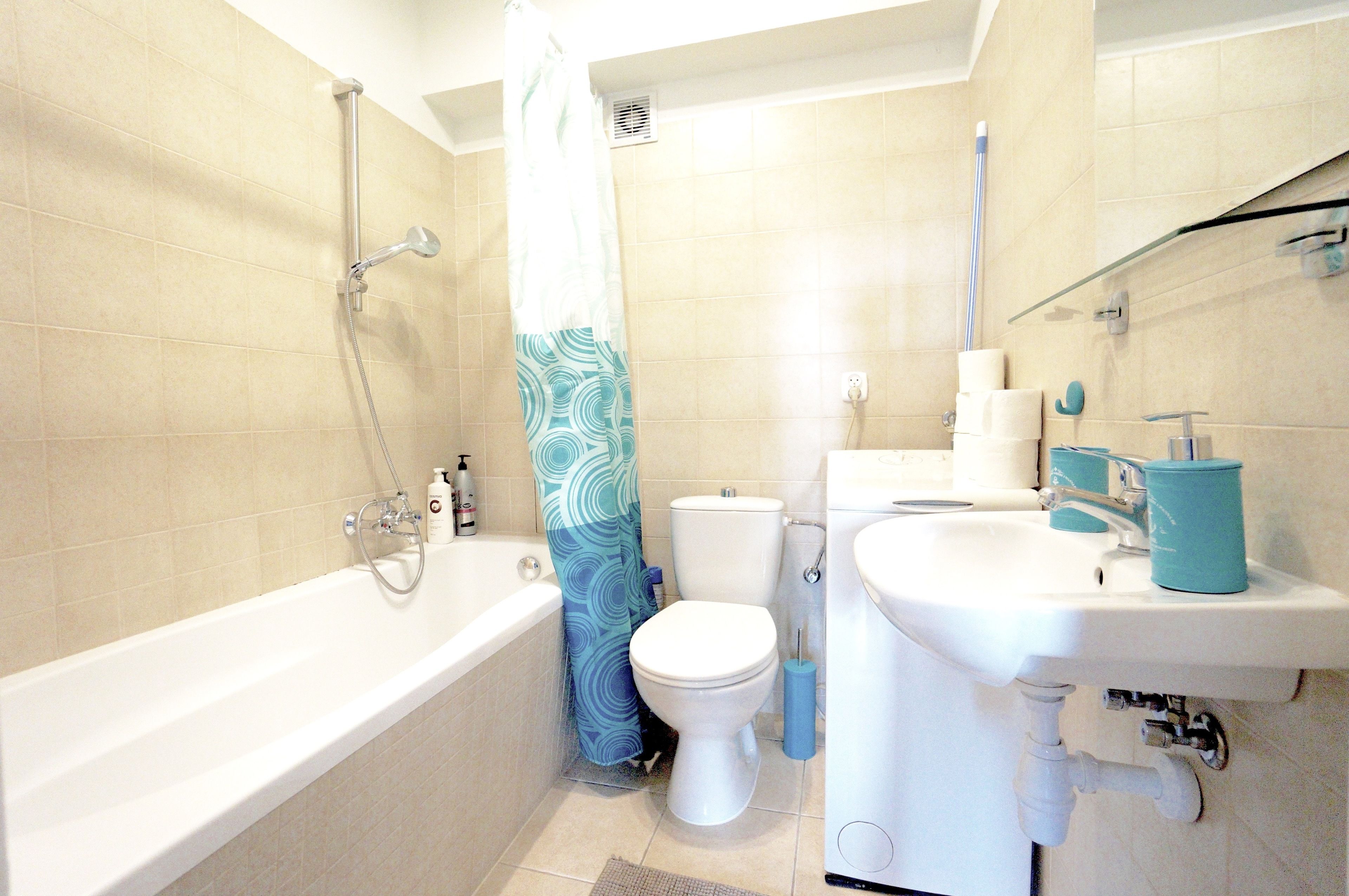 A bathroom with a bathtub, toilet, and sink.