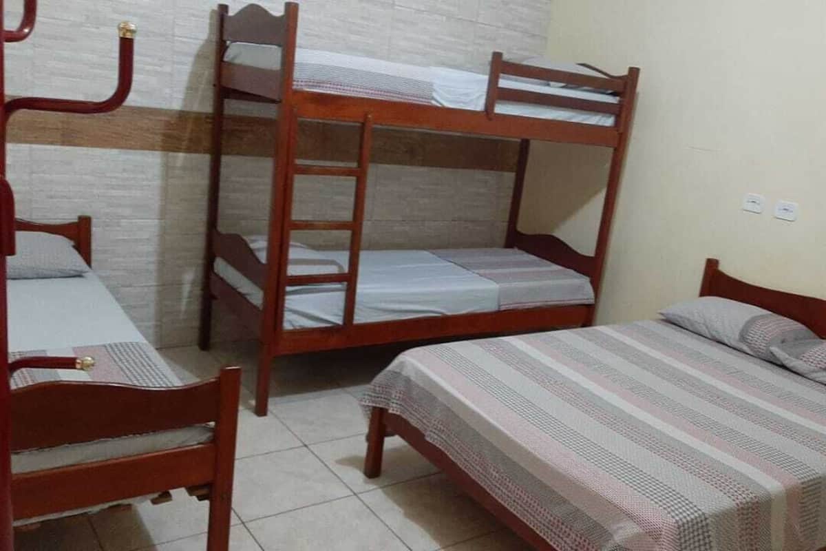 A room with three wooden bunk beds and a single bed.