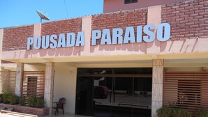 A building with a sign reading "POUSADA PARAISO" and a visible entrance with a glass door. - Pousada Paraiso (Bonito)