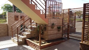 A staircase with metal railings leading to a brick platform with potted plants. - Pousada Paraiso (Bonito)