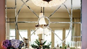 A dining table with a crystal chandelier, glassware, and a decorative centerpiece. - Hoeveld House (Sandton)