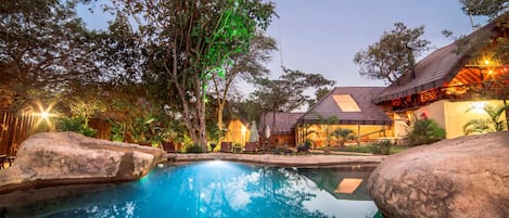 Una piscina al aire libre, sillones reclinables de piscina