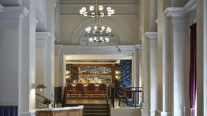 A spacious lobby with a bar area, wooden flooring, and a large chandelier. - The Darcy Hotel (Washington)