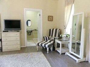 Suite de lujo, 1 habitación, vista al jardín | Área de sala de estar | Televisión