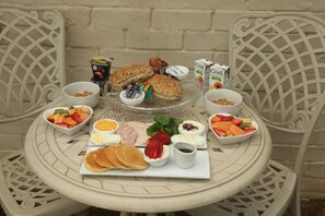 A table set with breakfast items including bread, eggs, fruit, and cereal. - The Plantation (Gqeberha (Port Elizabeth))