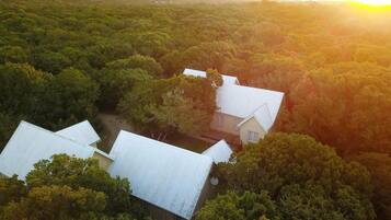 Uma propriedade rural com vários edifícios rodeada por uma floresta densa.