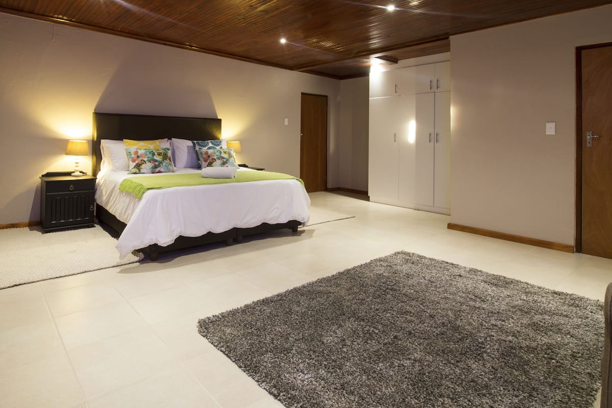 A bedroom with a bed, bedside tables, a wardrobe, and a carpet.