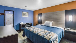 A hotel room with a bed, desk, and chair.