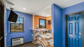 A reception area with a marble-patterned counter, a blue door, and a window with a view of a parking lot.
