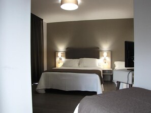 A hotel room with a bed, bedside tables, a desk, and a television. - Ton (Sanxenxo)